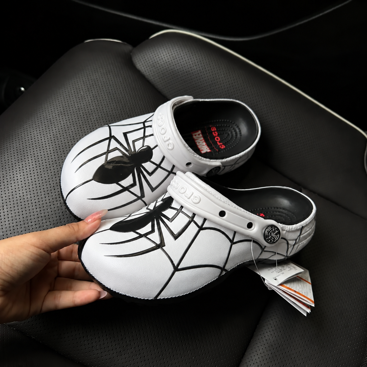 Paire de Crocs Marvel Spider-Man blanches avec araignée noire sur l'empeigne et étiquettes