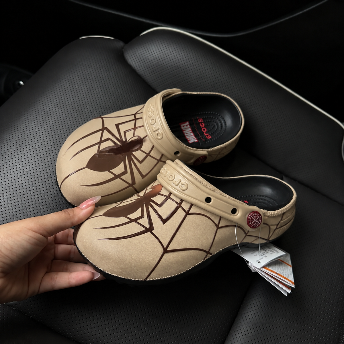 Crocs Spider-Man beiges vue de profil, motif toile marron et boutons toile rouges
