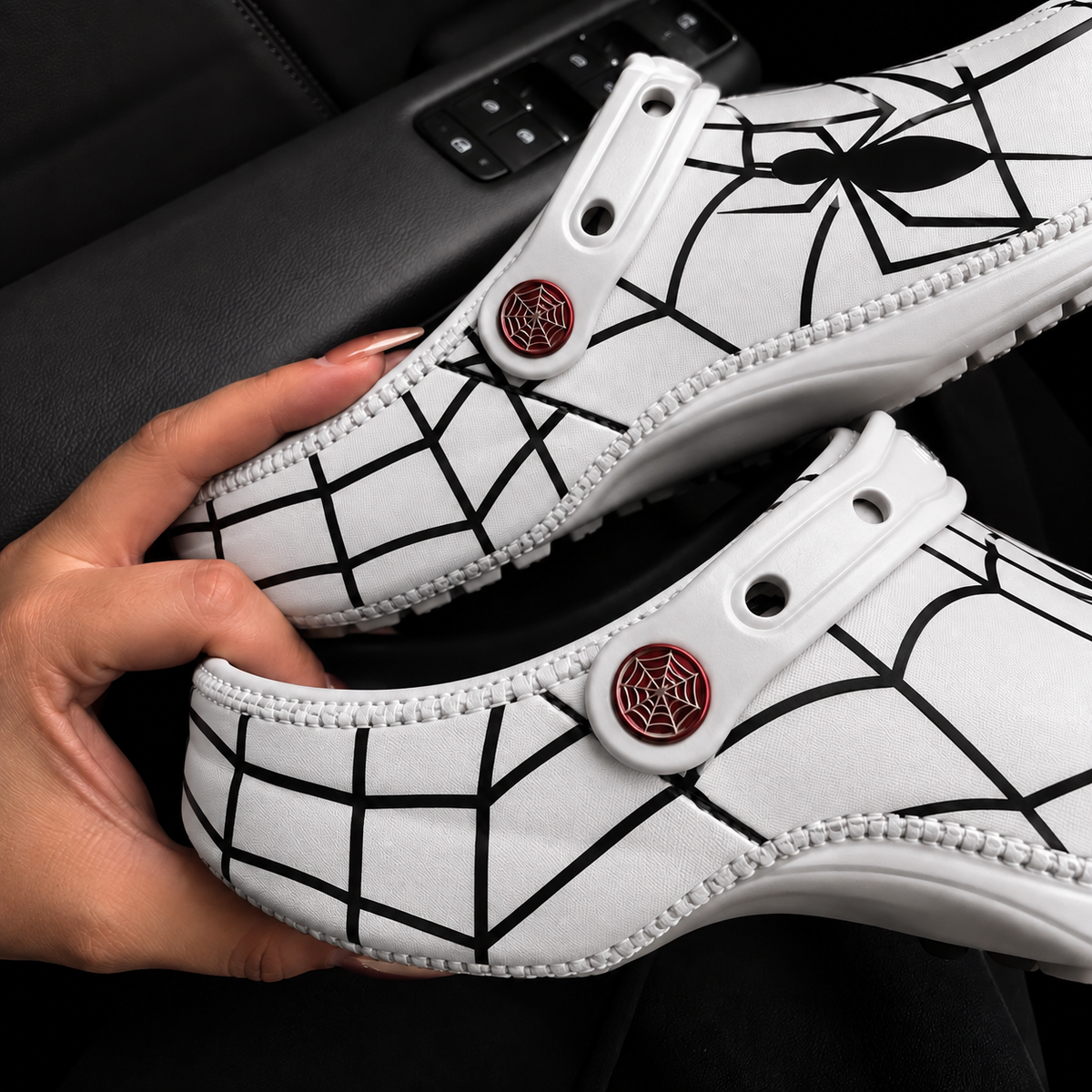 Crocs Spider-Man blanches vue de profil, motif toile noire et boutons toile rouges
